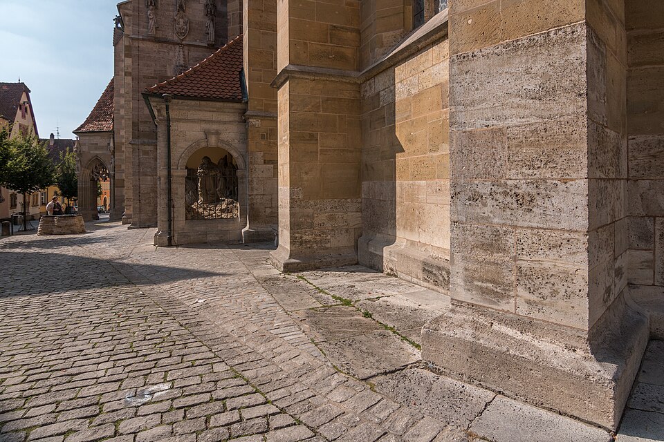 The tall Gothic St. Jakob's church of Rothenburg rising above half-timbered houses.