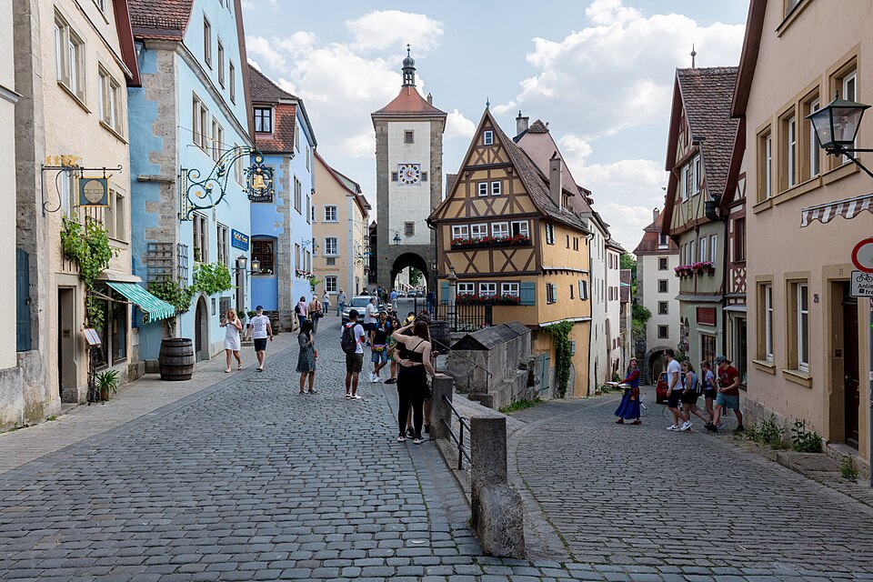 The Plönlein in Rothenburg ob der Tauber: a yellow half-timbered house on a fork below two gate towers.
